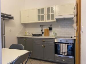 a kitchen with a stove and white cabinets and a table at Apartments Lav in Umag