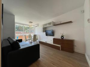 - un salon avec un canapé et une télévision dans l'établissement Live Lloret, à Lloret de Mar