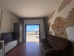 a living room with a couch and a brick wall at R135 Apartamento Playa in Calafell