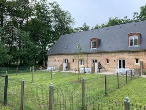 eine Backsteinscheune mit einem Zaun davor in der Unterkunft D2 CHARMANT duplex proche de la mer, avec jardin in Ingouville