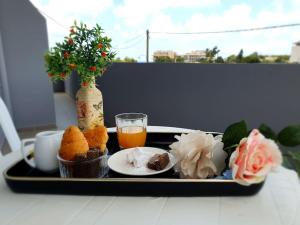 a tray with food and a drink on a table at M&M Modern Seaside Apartments Ammoudara Heraklion in Gázion