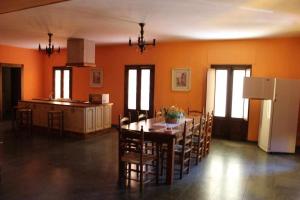 cocina y comedor con mesa y nevera en Cortijo Cabañas Apartamentos Rurales, en Arjona