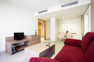 a living room with a red couch and a table at Apartaments Terraza Figueres in Figueres