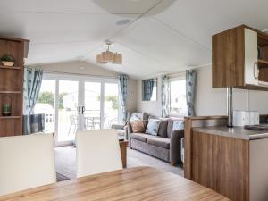 cocina y sala de estar con sofá y mesa en 205 The Meadows, en Newquay