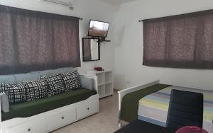 a bedroom with a bed and a tv on the wall at Villa Colonial suite n 3 familiar in Río San Juan