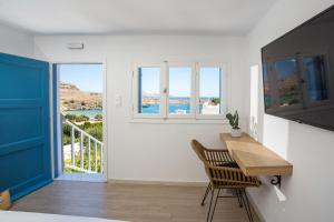 a room with a desk and a view of the ocean at Villa Euphrosyne in Líndos