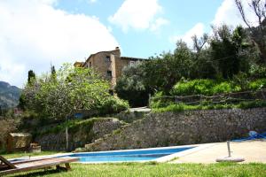 une piscine avec un bâtiment en arrière-plan dans l'établissement Sa Plana Petit Hotel, à Estellencs
