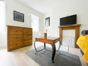 a bedroom with a desk and a tv on the wall at Pittville Studios - By Suitely in Cheltenham