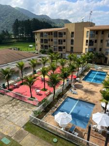 uma vista aérea de um hotel com piscina e palmeiras em Loft Condado Mangaratiba em Mangaratiba
