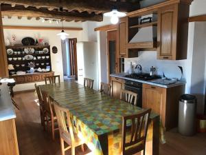 uma cozinha com mesa e cadeiras e uma cozinha com balcão em Vicinato Homestead em Molazzana