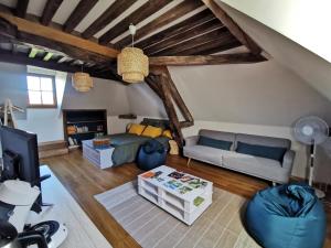 a living room with a couch and a tv at La ferme de la Terve in Bruailles