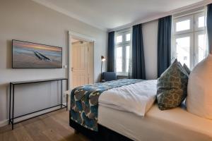 Habitación de hotel con cama y chimenea en Logierhaus Jonna Whg 15, en Westerland
