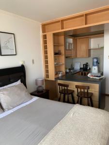 a bedroom with a bed and a kitchen with a counter at Departamento studio con exquisita vista in Viña del Mar