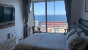 a bedroom with a bed and a view of the ocean at Departamento studio con exquisita vista in Viña del Mar