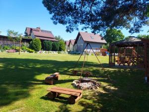 een park met een schommel en een speeltuin bij Domki u Marka in Polańczyk