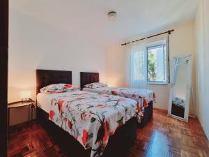 a bedroom with two beds and a window at Apartman Val in Rogoznica