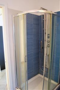 une douche avec une porte vitrée dans une salle de bain dans l'établissement Yellow House, à Albissola Marina 20 autres photos