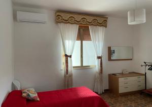 - une chambre avec un lit rouge et une fenêtre dans l'établissement Sunset, à Trapani