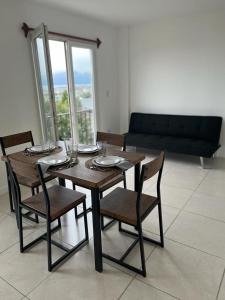 a dining room table with chairs and a couch at Hostel Los Cormoranes in Ushuaia