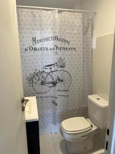 y baño con aseo y cortina de ducha para bicicletas. en Hostel Los Cormoranes en Ushuaia