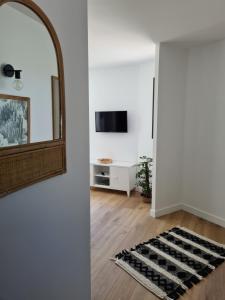 a living room with a mirror and a rug at Location LA BELLE - LA ROCHELLE B in La Rochelle