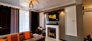 sala de estar con sofá y TV encima de la chimenea en Moon Plains Luxury Apartments en Nuwara Eliya