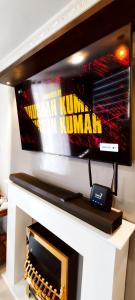 TV de pantalla plana con chimenea en Moon Plains Luxury Apartments en Nuwara Eliya