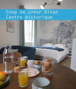 Una habitación con una mesa con bebidas y una cama en Dinan Château - Parking inclus, en Dinan
