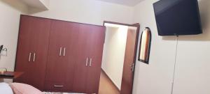 a bedroom with a large wardrobe and a television on the wall at SOYSOL.DEPARTAMENTOS in San Salvador de Jujuy