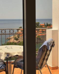 a balcony with a table and a view of the ocean at Villa Milan in Sveti Stefan