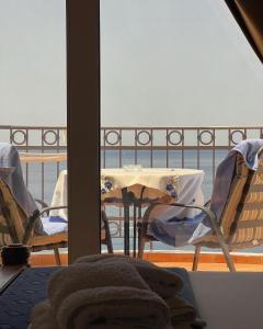 stół i krzesła na balkonie z widokiem na ocean w obiekcie Villa Milan w miejscowości Sveti Stefan