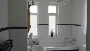ein Bad mit einer Badewanne, einem Waschbecken und einem Fenster in der Unterkunft Villa Anneliese in Weimar