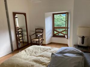 una camera con letto, finestra e sedie di Orchidée 1 et 2_ départ de randonnées a Mariac