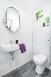a bathroom with a toilet and a sink and a mirror at Stunning 2 bed with outside balcony, super king beds and 75’’ TV! in Bradford