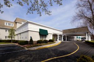 um grande edifício branco com estacionamento em Clinton Inn Hotel Tenafly em Tenafly