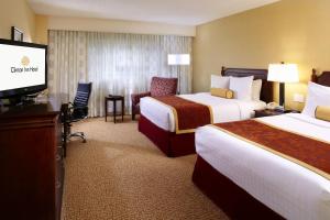 a hotel room with two beds and a flat screen tv at Clinton Inn Hotel Tenafly in Tenafly