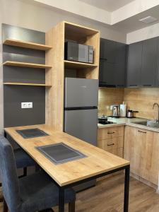 Il comprend une cuisine équipée d'une table en bois et d'un réfrigérateur. dans l'établissement Kechi Apart Hotel, à Tsaghkadzor