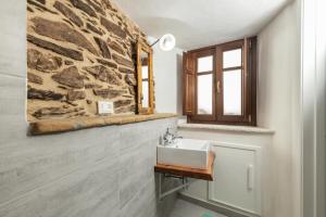 baño con lavabo y pared de piedra en Bed and Terrace Caterina, en Baunei