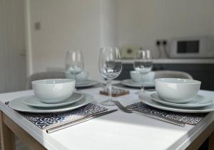 a table with bowls and plates and wine glasses at 34 One in Lytham St Annes
