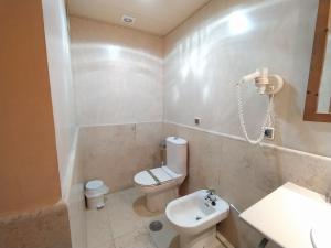 uma casa de banho branca com um WC e um lavatório em APARTAMENTO VISTAS LATERALES AL MAR SEGUNDA PLANTA em Isla Canela