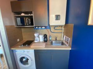 a small kitchen with a sink and a washing machine at Studio Confort Lorient Nouvelle Gare Hypercentre in Lorient