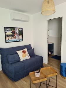 a living room with a blue couch and a table at Location LA REBELLE - LA ROCHELLE B in La Rochelle