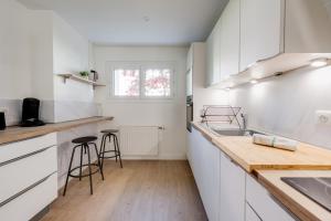 kuchnia z białymi szafkami i drewnianym blatem w obiekcie L'Annexe du 43 - Beautiful T3 for 4 people with balcony w Annecy