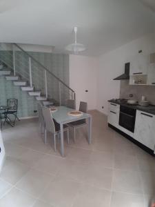 eine Küche mit einem Tisch und Stühlen sowie eine Treppe in der Unterkunft b&b casa vacanze Rebi house in San Giorgio Albanese