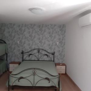 ein Schlafzimmer mit einem Bett in einem Zimmer mit Tapete in der Unterkunft b&b casa vacanze Rebi house in San Giorgio Albanese