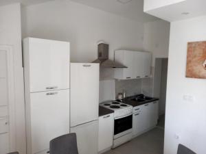 kuchnia z białymi urządzeniami i białymi szafkami w obiekcie Apartmani Dubrava 1 w Zagrzebiu