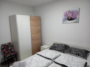 niewielka sypialnia z łóżkiem i obrazem na ścianie w obiekcie Apartmani Dubrava 1 w Zagrzebiu