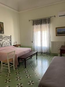 NovoliにあるLe Stanze del Monsignoreのベッドルーム1室(ベッド2台、テーブル、窓付)