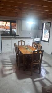 a wooden table and chairs in a kitchen at Escallonia House in San Martín de los Andes