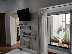 ベヘール・デ・ラ・フロンテーラにあるVivienda Turistica de Alojamiento Rural Casa Arenalejosの窓、ベッド、テーブルが備わる客室です。